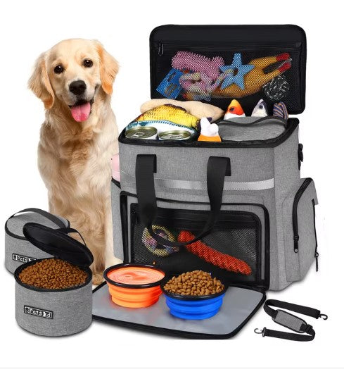 A golden retriever sitting next to a Pet Essentials Travel Organizer filled with pet supplies and travel bowls.