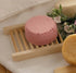 Eco Bath 6-Piece Kit featuring a round pink bath tablet on a wooden soap dish with floral accents.