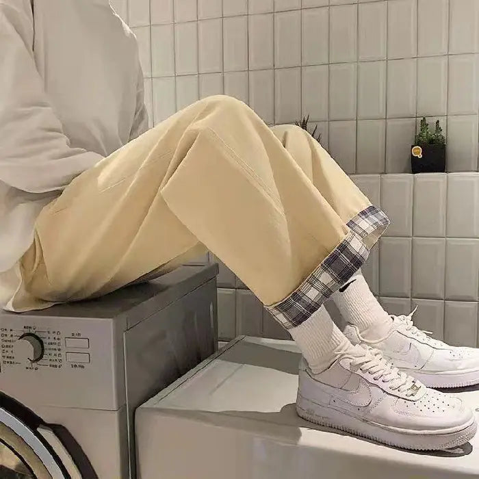 Chic High-Waist Cargo Denim displayed on a model sitting on a washing machine, featuring a plaid cuff and stylish sneakers.