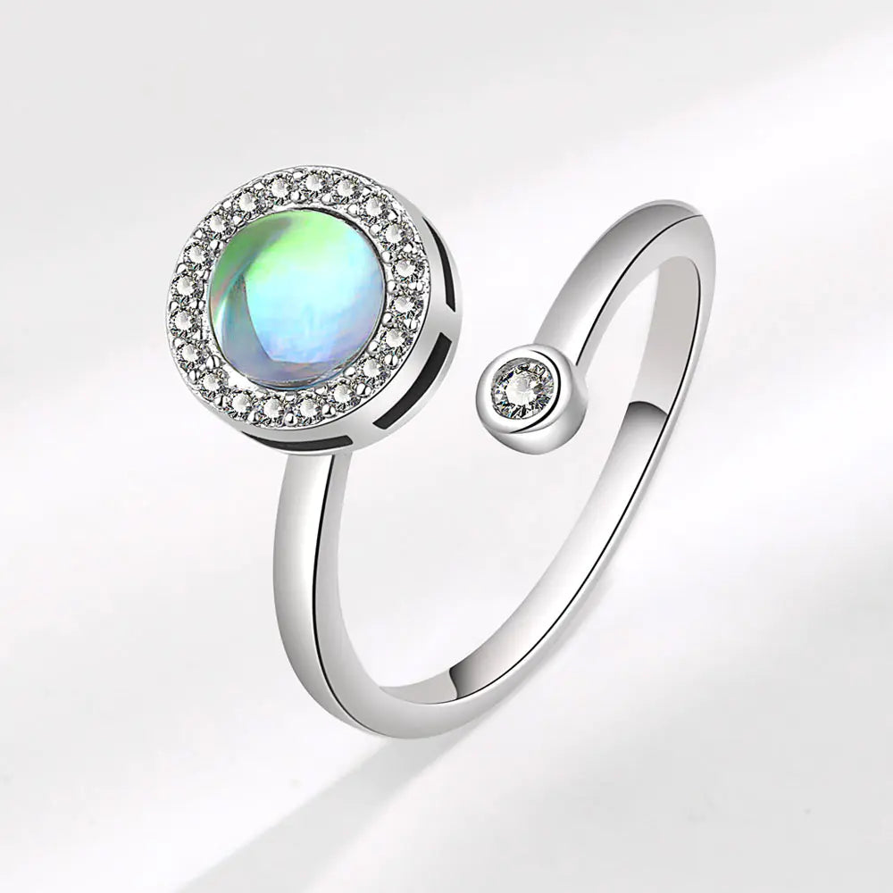 Chic Spin Ring for Fashion-Forward Women featuring a round opal surrounded by sparkling stones in a white gold finish.