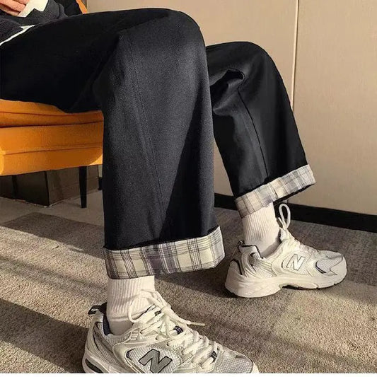 Chic High-Waist Cargo Denim featuring rolled cuffs and paired with trendy sneakers, seated in a stylish environment.