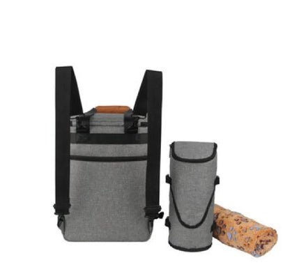 A golden retriever sitting next to a Pet Essentials Travel Organizer filled with pet supplies and travel bowls.